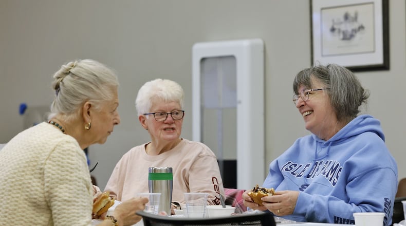 Erla Aulfinger, left, and Patty Powell, middle, and Kathy Dixon laugh as they gather for lunch at the MidPointe Library in Trenton Wednesday, Nov. 22, 2023. Adults 60 and older meet every Wednesday for a provided meal. Registration is required. NICK GRAHAM/STAFF