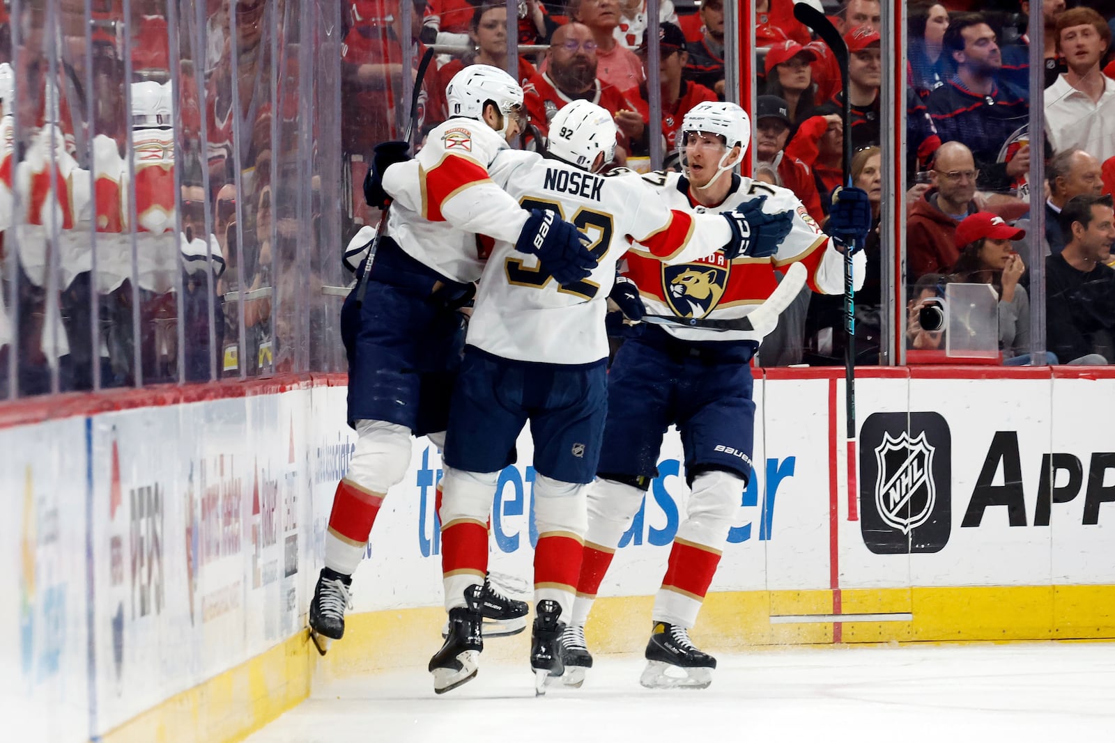 Florida Panthers' A.J. Greer (10) celebrates his goal against the Carolina Hurricanes with teammates Tomas Nosek (92) and Niko Mikkola (77) during the second period of Game 1 of the NHL hockey Stanley Cup Eastern Conference finals in Raleigh, N.C., Tuesday, May 20, 2025. (AP Photo/Karl DeBlaker)