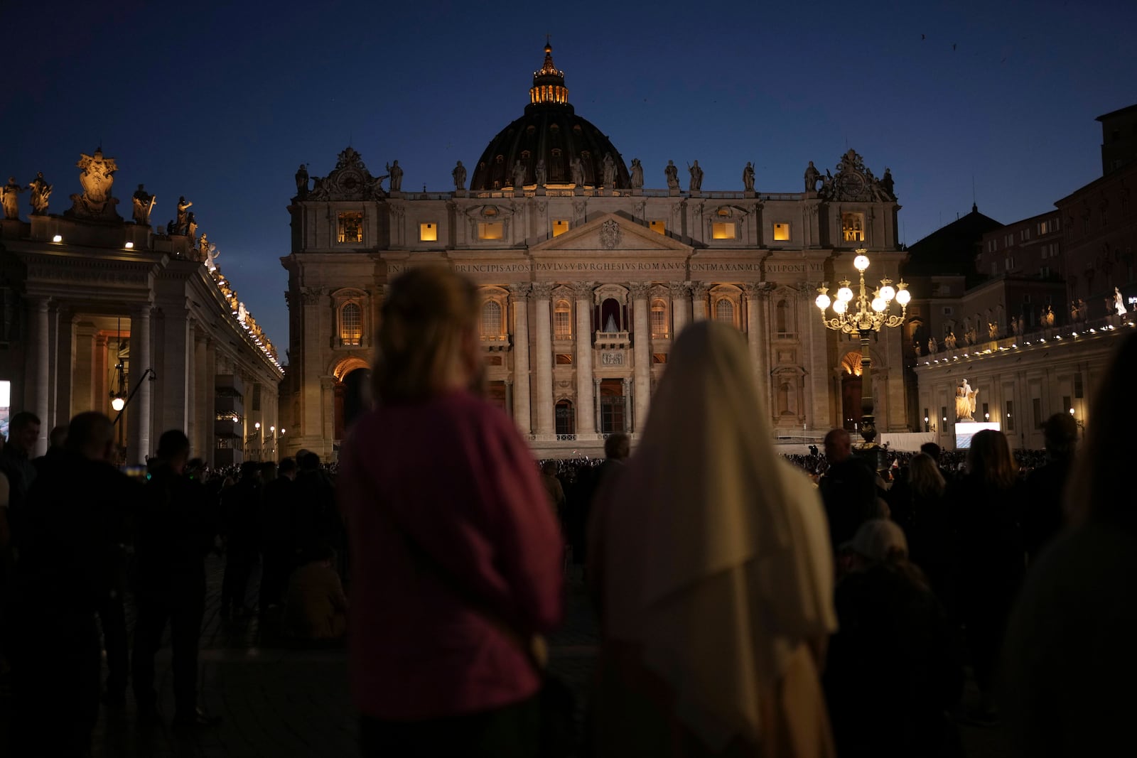 People gather in St Peter's Square as they wait to see the smoke billow from the chimney of the Sistine Chapel in St Peter's Square during the cardinals' conclave to elect a new pope, at the Vatican, Wednesday, May 7, 2025. (AP Photo/Francisco Seco)