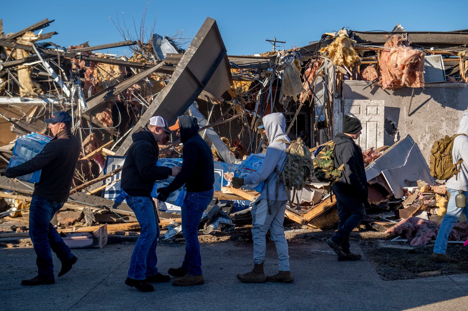 Volunteers deliver water in Mayfield, Ky. on Monday, Dec. 13, 2021, after a tornado across the area. Determining how many people died in the tornadoes that ravaged the central U.S. on Friday has been a challenging task so far, with estimates fluctuating as search teams continue to spread out amid vast fields of rubble in an effort to rescue the living and account for the dead. (Johnny Milano/The New York Times)