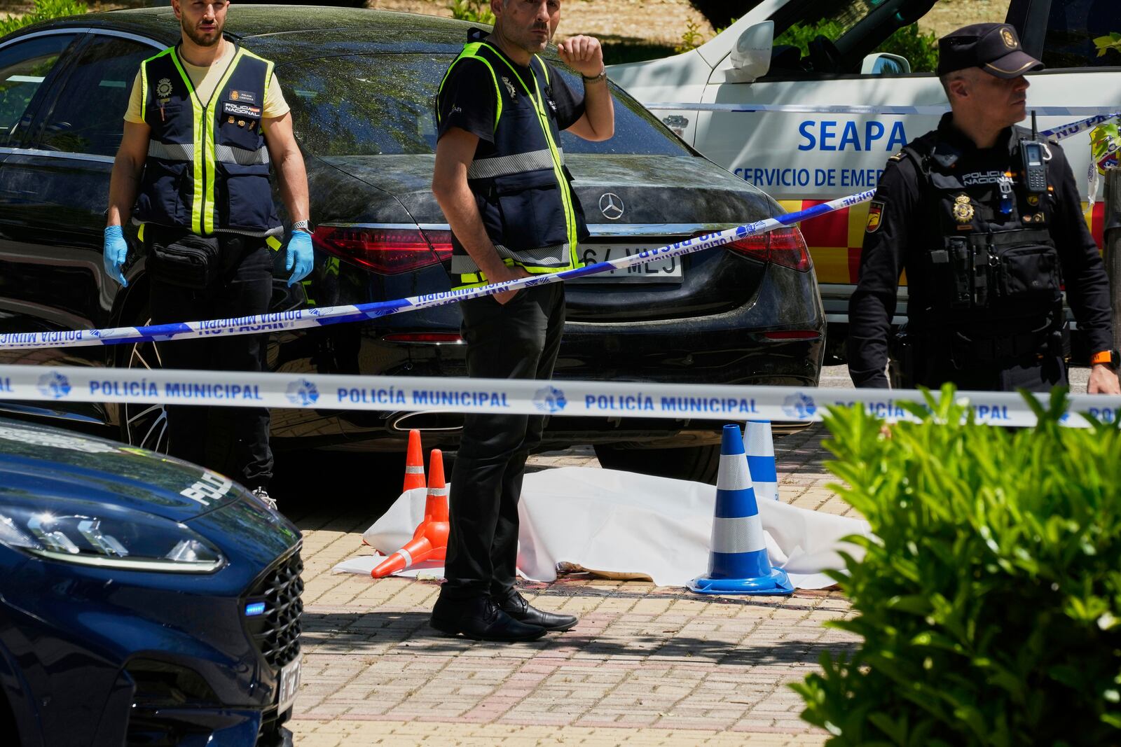 Members of the judicial police at the scene after Andriy Portnov, an adviser to former Ukrainian president Viktor Yanukovych was shot, outside a school in Madrid, Spain, Wednesday, May 21, 2025. (AP Photo/Paul White)