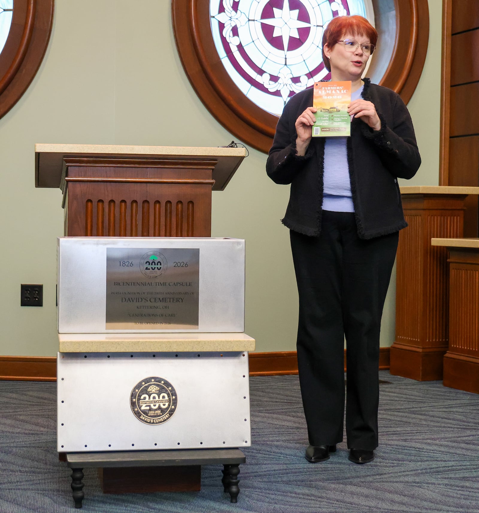 David's Cemetery Board of Trustees vice president Kathleen Druffner holds a copy of the 2026 Farmer's Almanac she placed in a time capsule during a ceremony in the cemetery's mausoleum chapel on Thursday, Jan. 8. The cemetery is celebrating its 200th anniversary and is designating the time capsule to be opened in 100 years during its 300th anniversary. The cemetery will be collecting items throughout the year for the time capsule. BRYANT BILLING/STAFF