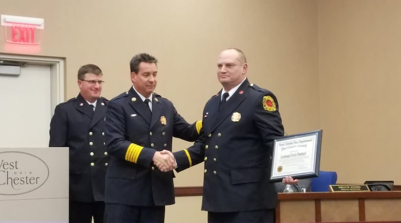West Chester Township Fire Department Lt. David Eberhard (right) was presented the “Fire Chief’s Award” for his role in being first on the scene to save a choking infant at a local restaurant in early December. Eberhard, shown being congratulated at a recent township trustees’ meeting by Fire Chief Rick Prinz, is the first firefighter to win the rare award since 2007.