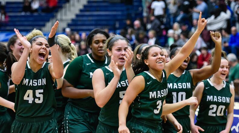 Mason players celebrate their Division I regional championship after defeating Lakota West 54-51 on Saturday night at Fairmont’s Trent Arena. NICK GRAHAM/STAFF