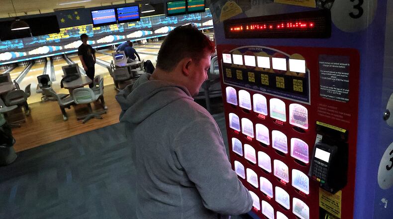 FILE PHOTO: Brandon Oty looks over the Ohio Lottery instant games in a kiosk at Victory Lanes bowling alley in Springfield. BILL LACKEY/STAFF