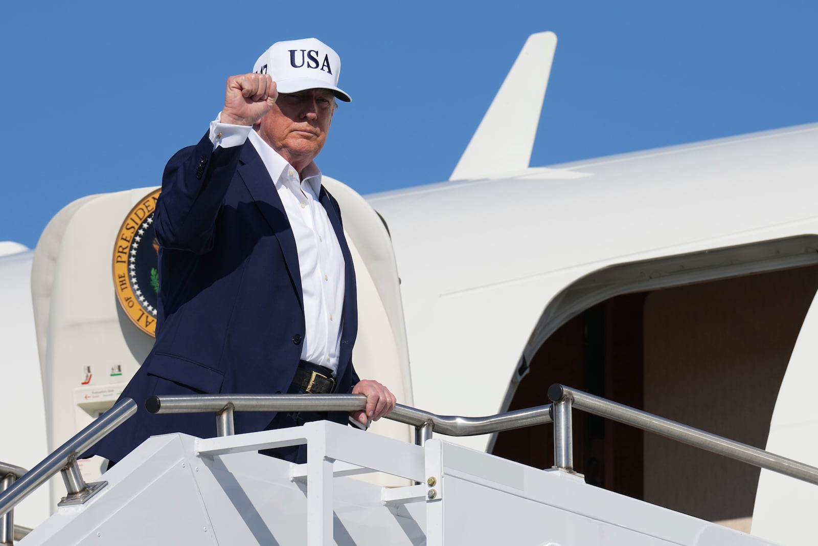 President Donald Trump gestures as he boards Air Force One at Morristown Municipal Airport in Morristown, N.J., Sunday, July 6, 2025, en route to Washington. (AP Photo/Jacquelyn Martin)
