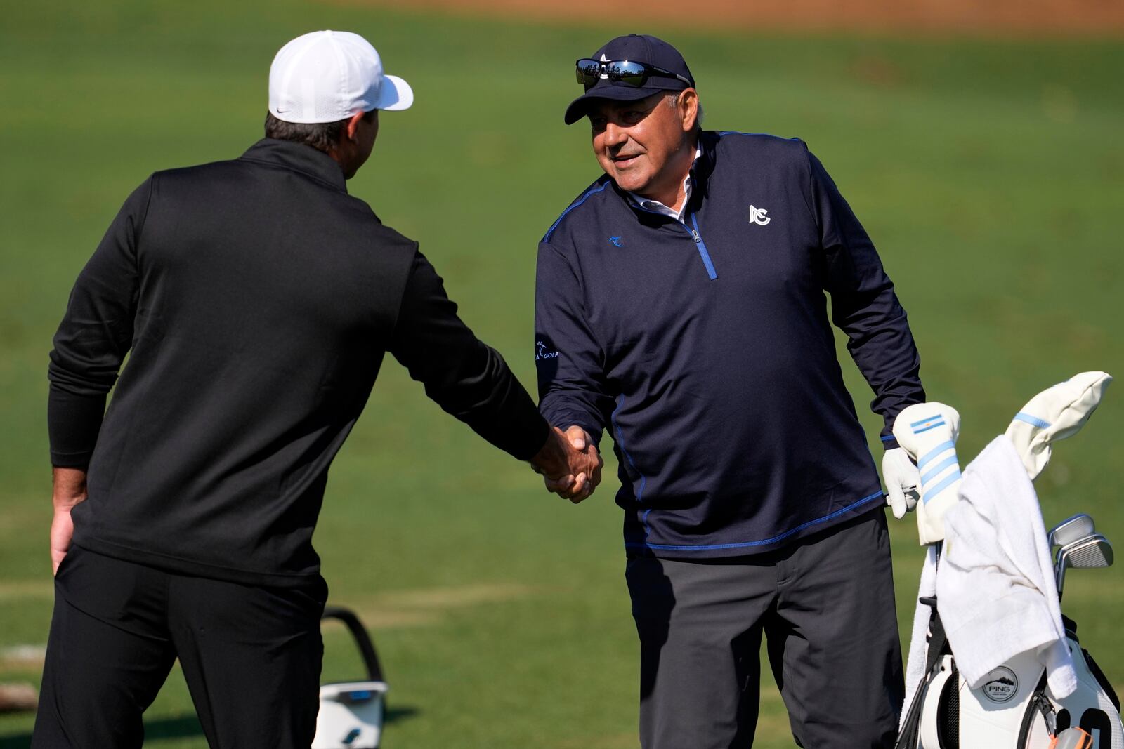 Brooks Koepka, left, and Angel Cabrera, of Argentina, meet on the range during a practice around at the Masters golf tournament, Wednesday, April 9, 2025, in Augusta, Ga. (AP Photo/George Walker IV)