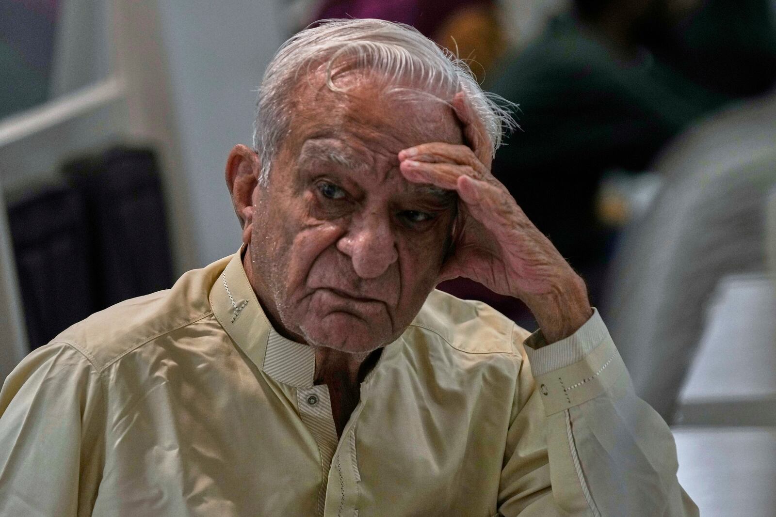 A dejected investor waits to restart trading, suspended for an hour following a 5% drop in in its main index at the Pakistan Stock Exchange (PSE), in Karachi, Pakistan, Monday, April 7, 2025. (AP Photo/Fareed Khan)