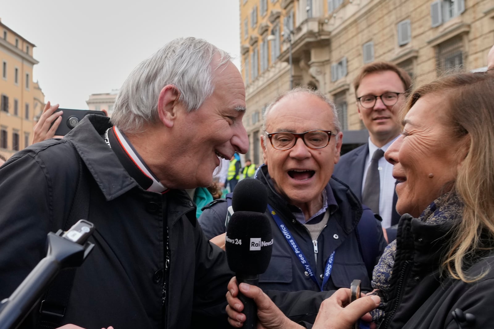 Cardinal Matteo Zuppi, left, is approached by reporters as he arrives for a college of cardinals' meeting, at the Vatican, Monday, April 28, 2025. (AP Photo/Gregorio Borgia)