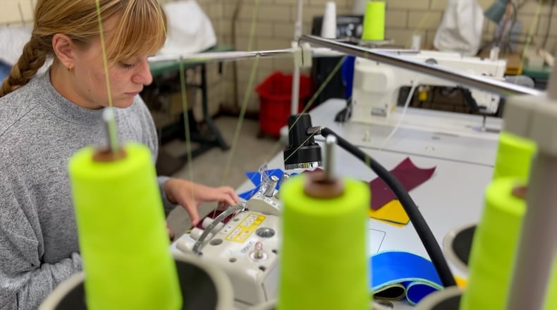 Marie Hamilton works at Sew Valley. She says using scrap materials for projects is part of what attracted her to the position. She's one of the workers who helped make almost 3,800 flags for BLINK. KEITH BIERYGOLICK/WCPO