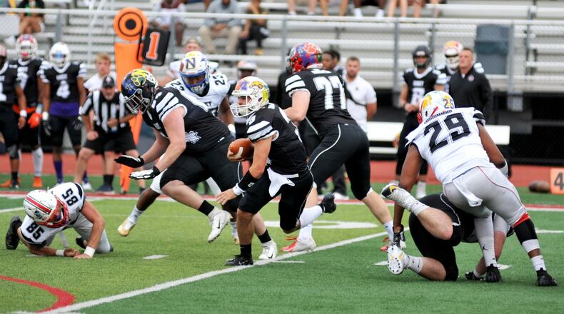Western Brown quarterback Josh Taylor of the East runs between Fairfield’s Mekiyell Muhammad (29) and Talawanda’s Christopher Richardson (85) of the West on Thursday night during the 44th Southwestern Ohio Football Coaches Association Ron Woyan East-West All-Star Game at Kings Stadium. The East won 39-7. RICK CASSANO/STAFF