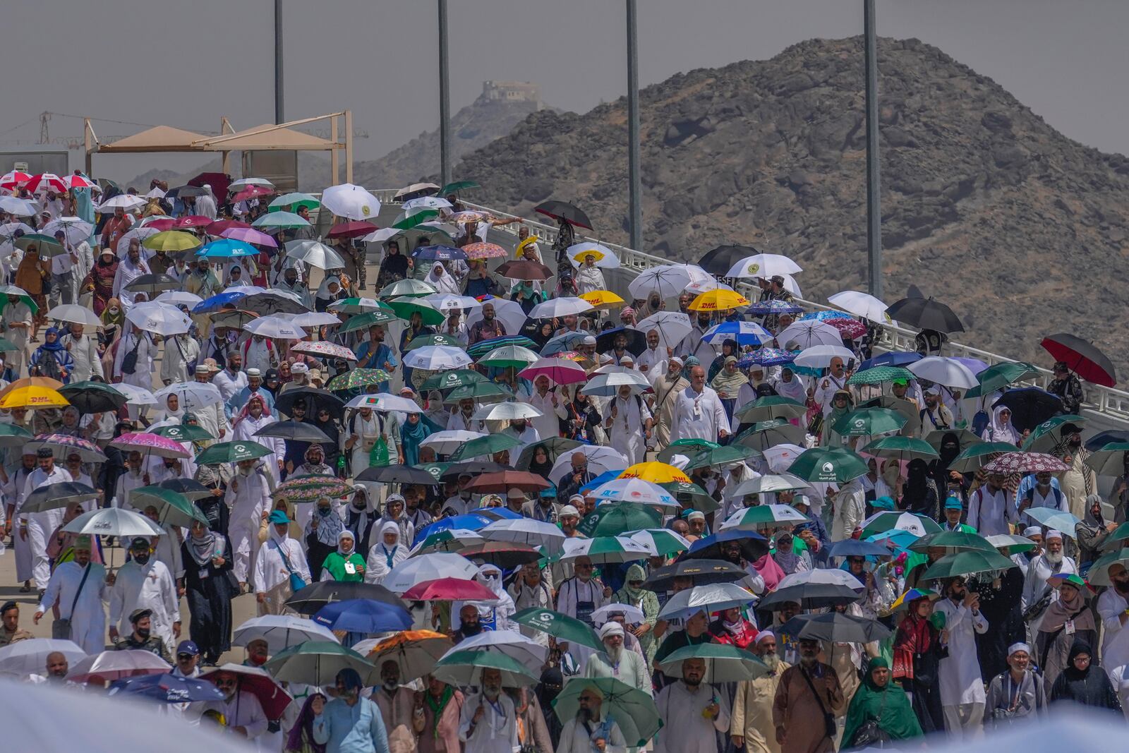FILE - Muslim pilgrims use umbrellas to shield themselves from the sun as they arrive to cast stones at pillars in the symbolic stoning of the devil during the annual hajj, in Mina, near the holy city of Mecca, Saudi Arabia, Tuesday, June 18, 2024. (AP Photo/Rafiq Maqbool, File)