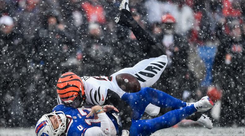 Buffalo Bills quarterback Josh Allen (17) takes a hit from Cincinnati Bengals defensive end Joseph Ossai (58) during the second quarter of an NFL division round football game, Sunday, Jan. 22, 2023, in Orchard Park, N.Y. The play was ruled an incomplete pass. (AP Photo/Adrian Kraus)