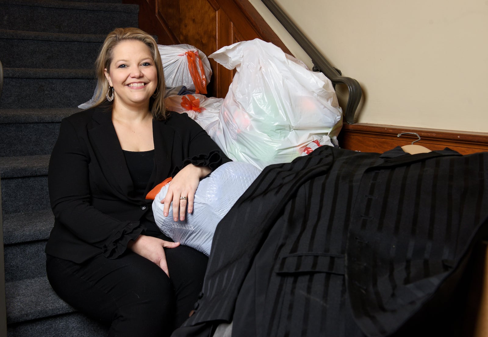 Jeri Lewis sits among clothing donations for her new non-profit venture, Job Threads, geared toward supplying dress clothing for unemployed people for interviews. NICK GRAHAM / STAFF