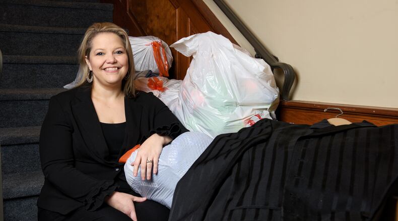 Jeri Lewis sits among clothing donations for her new non-profit venture, Job Threads, geared toward supplying dress clothing for unemployed people for interviews. NICK GRAHAM / STAFF