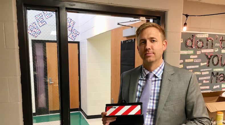 Lakota Woodland Elementary Principal John Wise holds the district’s latest security tool designed to thwart an active shooter inside the building. The “Bearacade” door jam is made of steel and can be attached in seconds by a teacher to keep any violent threat outside of their classroom. The security device is now in all 1,200 classrooms in the Butler County district. (Photo by Michael D. Clark/Journal-News)