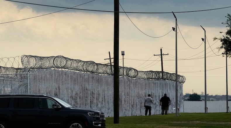 FILE - Security walk outside "Camp 57," a facility to house immigration detainees at the Louisiana State Penitentiary in Angola, La., on Sept. 3, 2025. (AP Photo/Gerald Herbert, File)