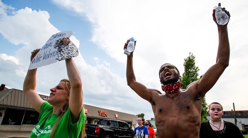 More than 75 people gathered Wednesday at the Middletown City Building as protestors marches through downtown Middletown. The groups gathered in response to the death of George Floyd in police custody in Minnesota. Myranda Lucarelli, left, and Joshua Oatneal chant as they walk along Central Avenue. NICK GRAHAM / STAFF