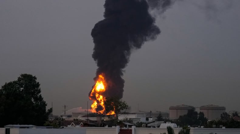Fire and plumes of smoke rises after s drone struck a fuel tank forcing the temporary suspension of flights. near Dubai International Airport, in United Arab Emirates, early Monday, March 16, 2026. (AP Photo)