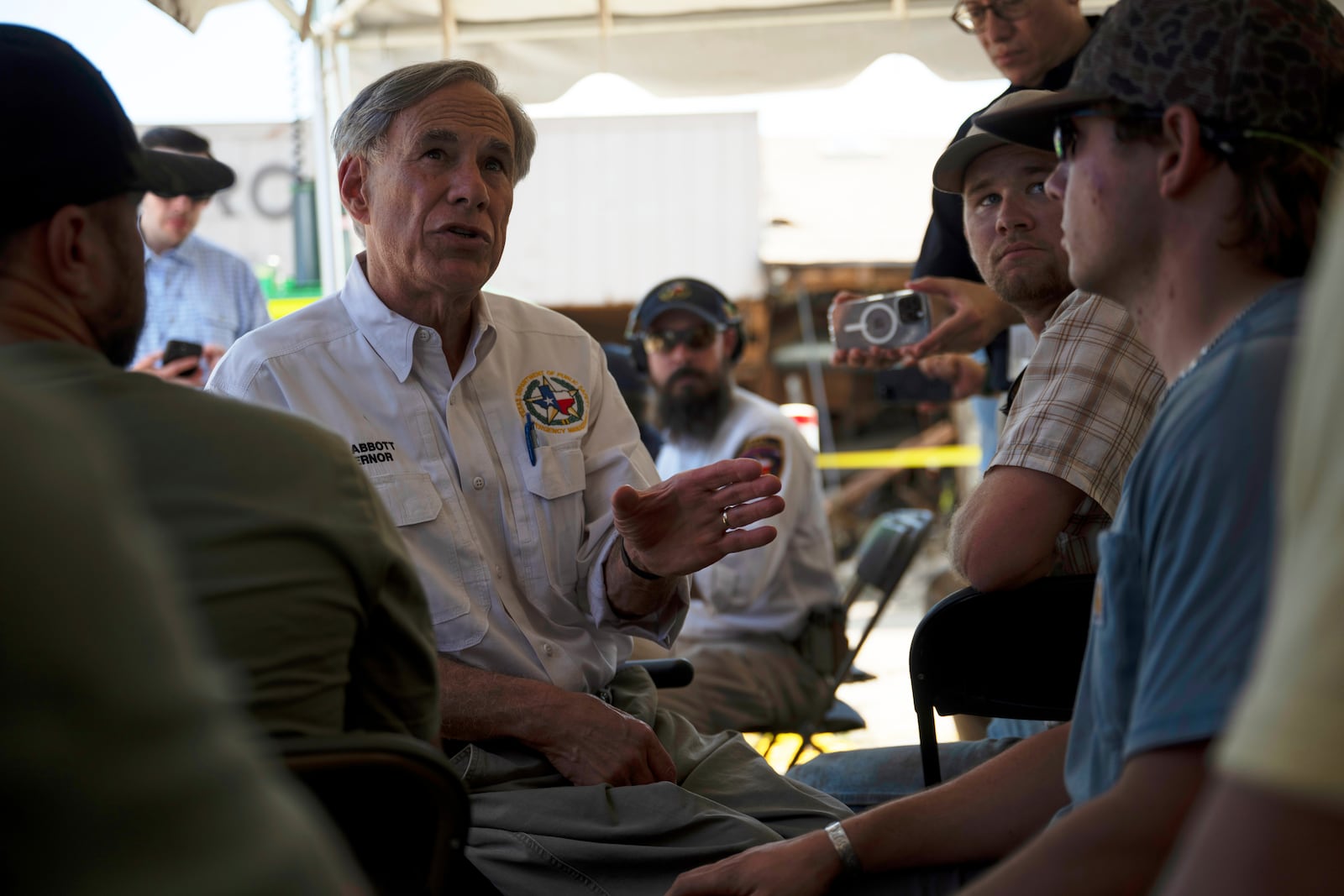 Texas Gov. Greg Abbott speaks to residents and volunteers before a press conference on Tuesday, July 8, 2025, in Hunt, Texas. (AP Photo/Eli Hartman)