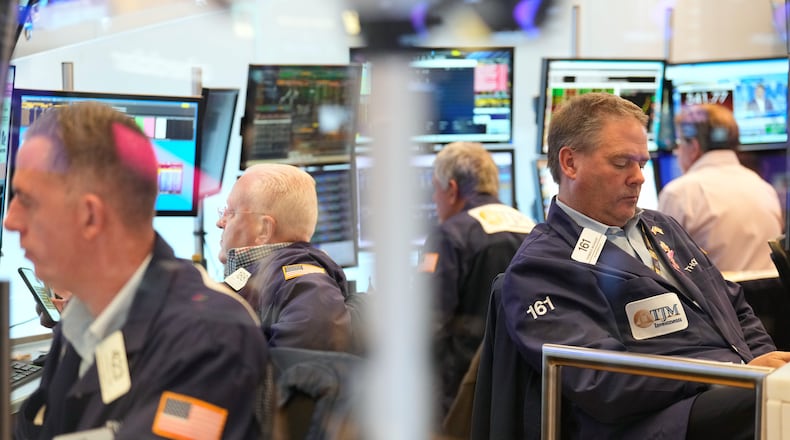 Traders, including Thomas McCauley, second from right, work on the floor at the New York Stock Exchange in New York, Wednesday, Oct. 29, 2025. (AP Photo/Seth Wenig)