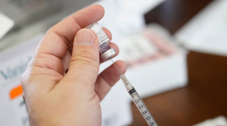 Walgreens pharmacist Chris McLaurin prepare to fill a syringe with Pfizer-BioNTech COVID-19 vaccine before vaccinating the residents at Harmony Court Assisted Living, Tuesday, Jan. 12, 2021, in Jackson, Miss. The Mississippi State Department of Health reports there have been 9,796 cases of the coronavirus in long-term care facilities and 1,791 deaths as of Tuesday. (AP Photo/Rogelio V. Solis)