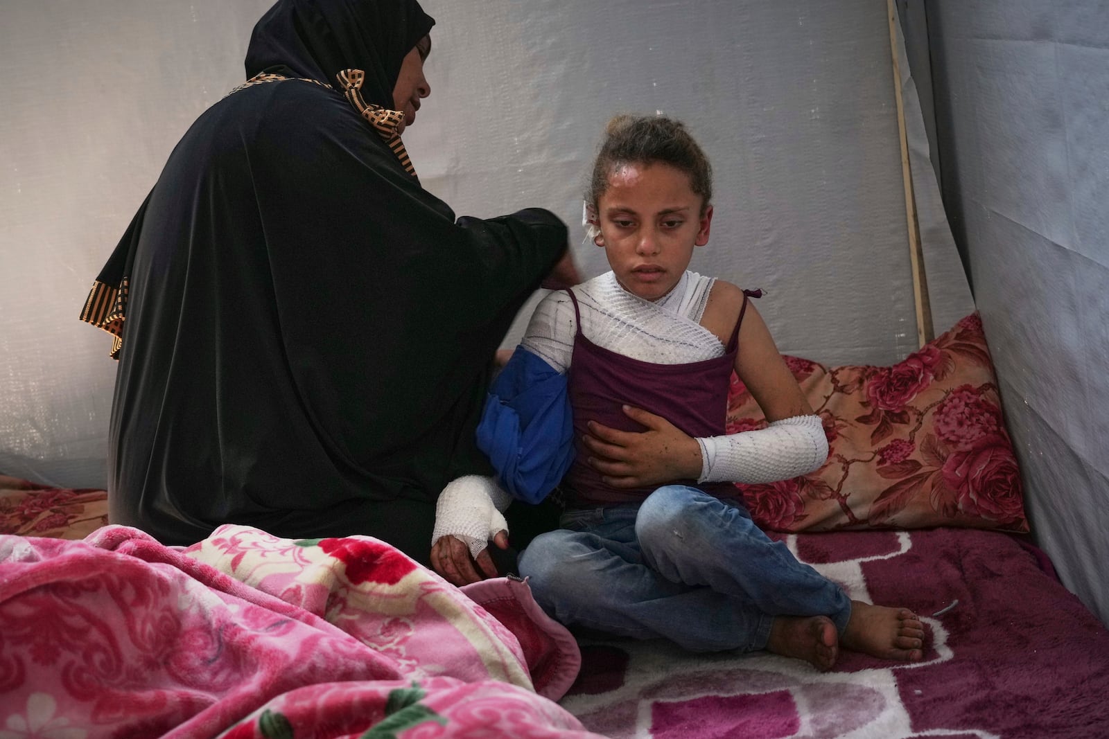Haneen al-Khazandar cares for her 10-year-old daughter Mira who was severely burned on her arms and chest when an Israeli army strike hit near her tent, in Khan Younis, Gaza Strip, Sunday, May 4, 2025.(AP Photo/Abdel Kareem Hana)