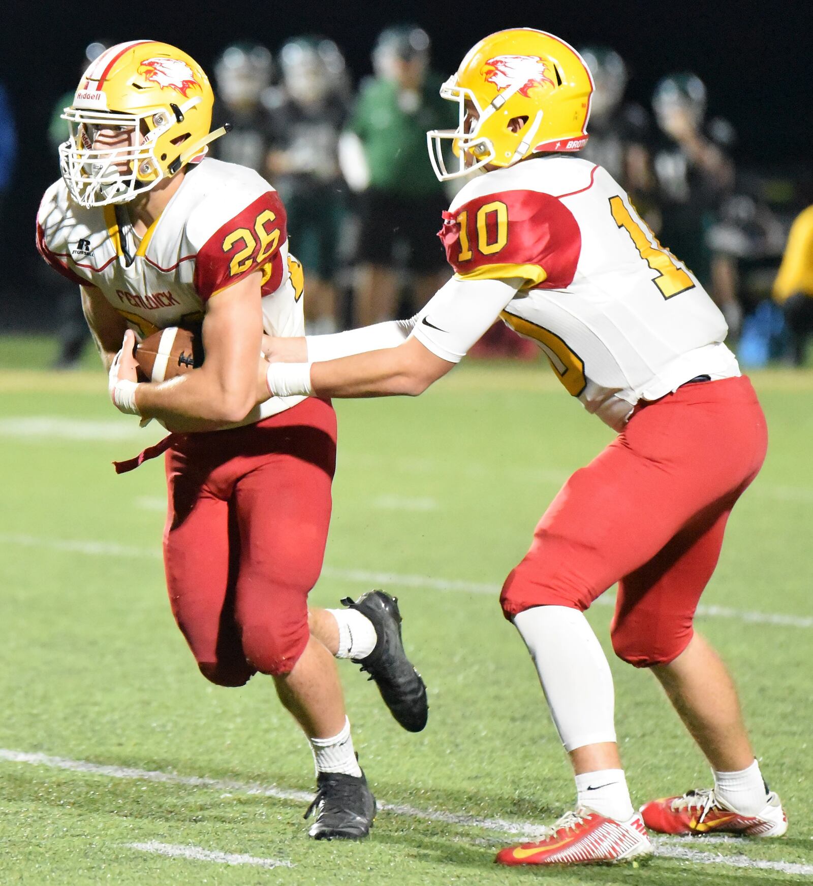 Fenwick quarterback Sully Janeck hands off to Logan Miller during Friday night’s game against McNicholas at Penn Station Stadium in Cincinnati. Fenwick earned a 57-26 triumph. CONTRIBUTED PHOTO BY ANGIE MOHRHAUS