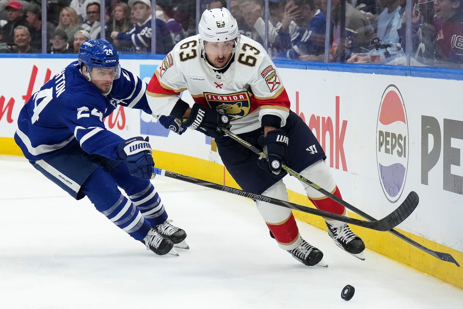 Florida Panthers forward Brad Marchand (63) and Toronto Maple Leafs forward Scott Laughton (24) vie for control of the puck during the third period of Game 1 in an NHL hockey second-round playoff series in Toronto, Monday, May 5, 2025. (Nathan Denette/The Canadian Press via AP