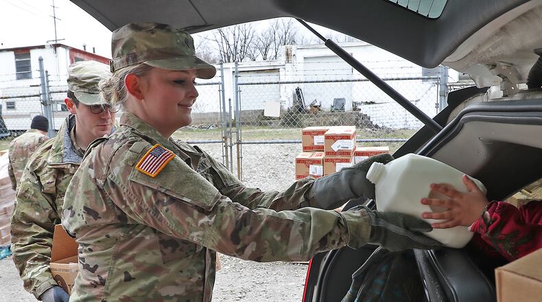 A pop-up food pantry is from 10 a.m. to noon Feb. 20 at the Warren County Fairgrounds, 556 N. Broadway St. in Lebanon, and is being conducted by Shared Harvest Foodbank based in Fairfield. Pictured are members of the Ohio National Guard, based in Springfield, who helped distribute food July 10, 2020, at the Second Harvest Food Bank as a line of cars, waiting for food, wrapped around the food bank. BILL LACKEY/STAFF
