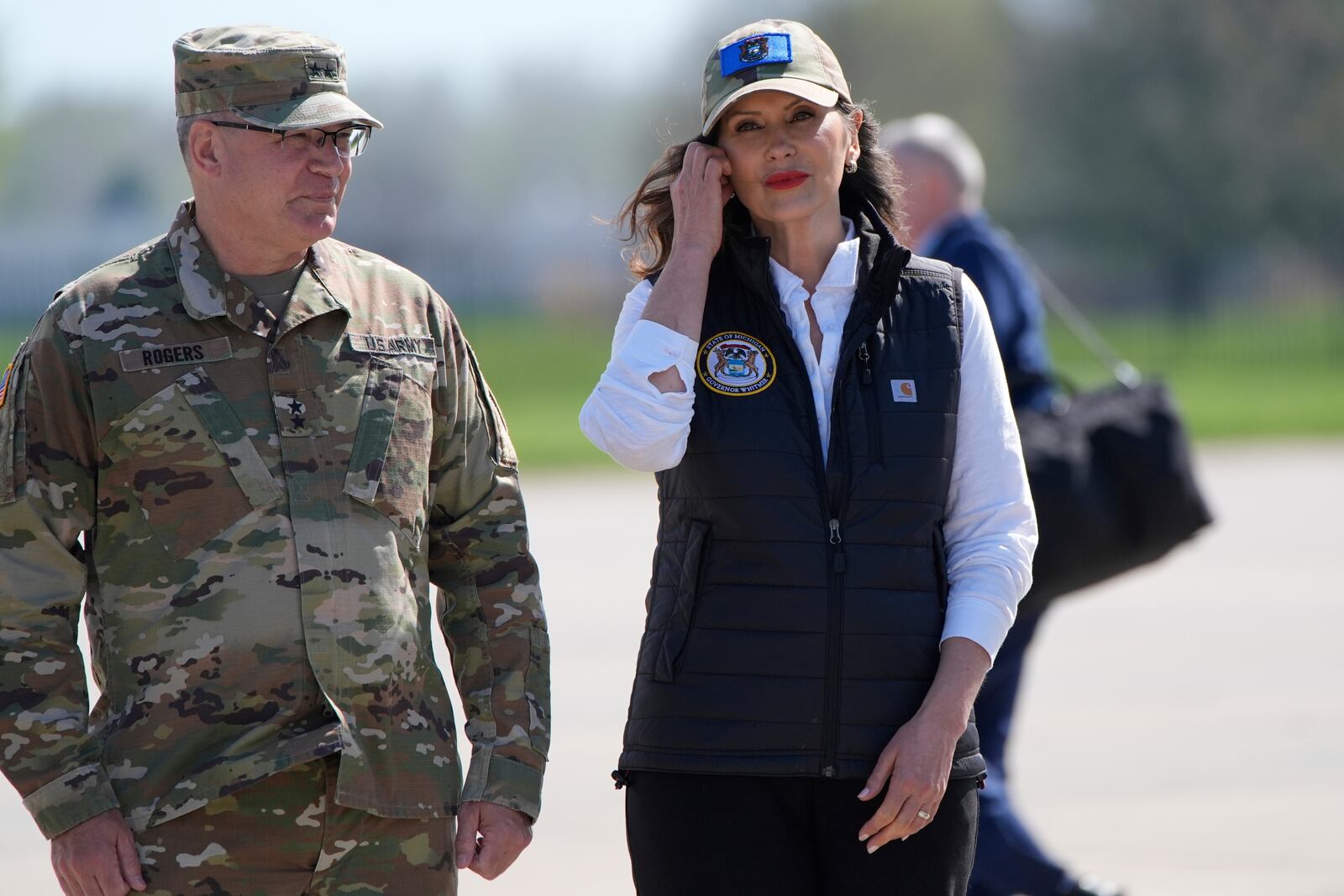 Michigan Gov. Gretchen Whitmer waits with Michigan National Guard adjutant general Major Gen. Paul Rogers to greet President Donald Trump at Selfridge Air National Guard Base, Tuesday, April 29, 2025, in Harrison Township, Mich. (AP Photo/Alex Brandon)