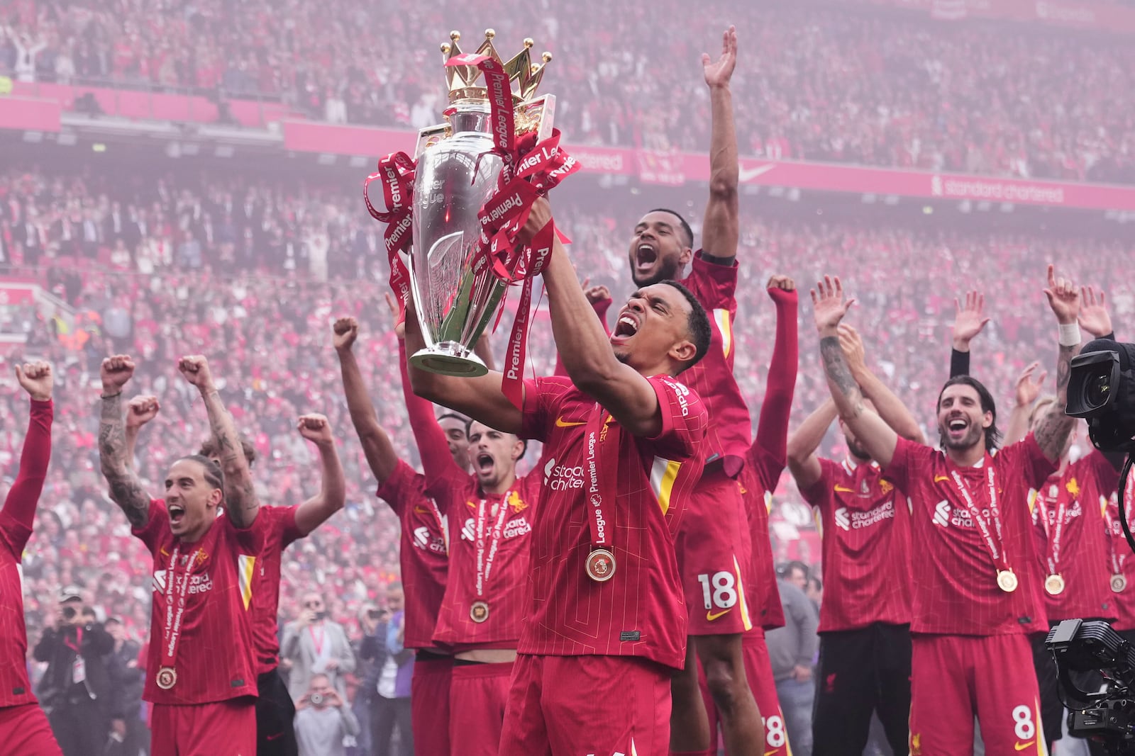 Liverpool's Trent Alexander-Arnold holds the winner's trophy as he celebrates with teammates after the English Premier League soccer match between Liverpool and Crystal Palace at the Anfield stadium in Liverpool, England, Sunday, May 25, 2025. (AP Photo/Jon Super)