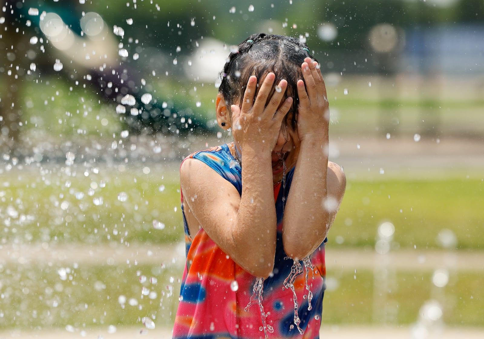 Zoe Martinez, 7, plays in the splash pad at Booker T. Washington Community Center Tuesday, June 10, 2025 in Hamilton. NICK GRAHAM/STAFF