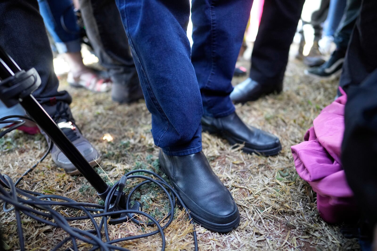 The feet of Brazil's former President Jair Bolsonaro are photographed as he stops to speak with the press while leaving the Secretariat of Penitentiary Administration after the Supreme Court ordered him to be fitted with an electronic ankle monitor in Brasilia, Brazil, Friday, July 18, 2025. (AP Photo/Eraldo Peres)