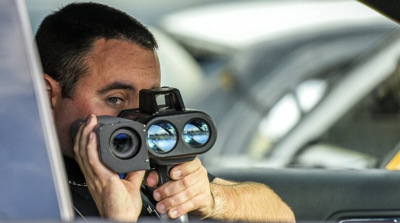 New Miami Police officer Mark Bennett uses a speed enforcement camera along US 127. A Butler County judge is expected today to rule on a case that could order New Miami to repay $3 million in illegally collected ticket fines. NICK GRAHAM/STAFF