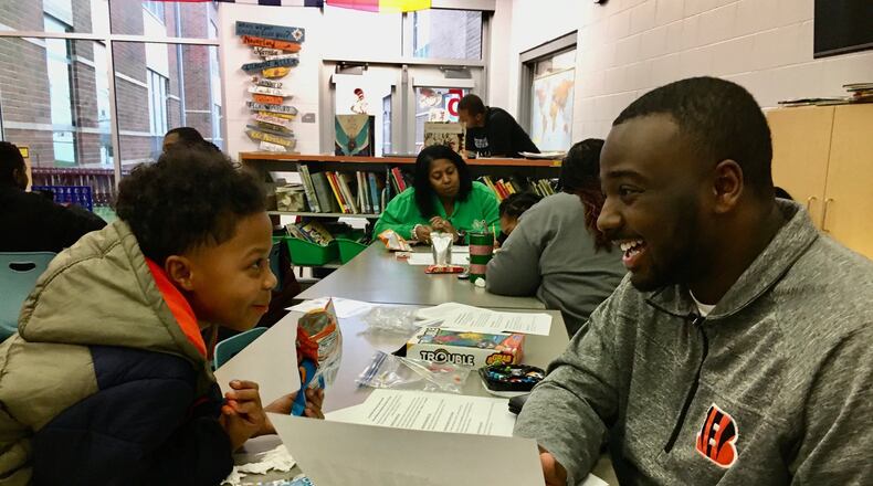 A new mentoring program at Fairfield Schools’ Compass Elementary started recently with lots of smiles and playful first introductions between volunteer mentor adults and their young mentees. Second-grader Kingston Wright hits it off with his new mentor Daryan Martin as they bond over a homework assignment. (Photo By Michael D. Clark/Journal-News)
