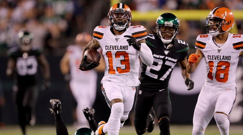 EAST RUTHERFORD, NEW JERSEY - SEPTEMBER 16: Odell Beckham Jr. #13 of the Cleveland Browns breaks free from Brian Poole #34 and Darryl Roberts #27 of the New York Jets to run the ball 89 yards in for the touchdown in the third quarter at MetLife Stadium on September 16, 2019 in East Rutherford, New Jersey. (Photo by Elsa/Getty Images)