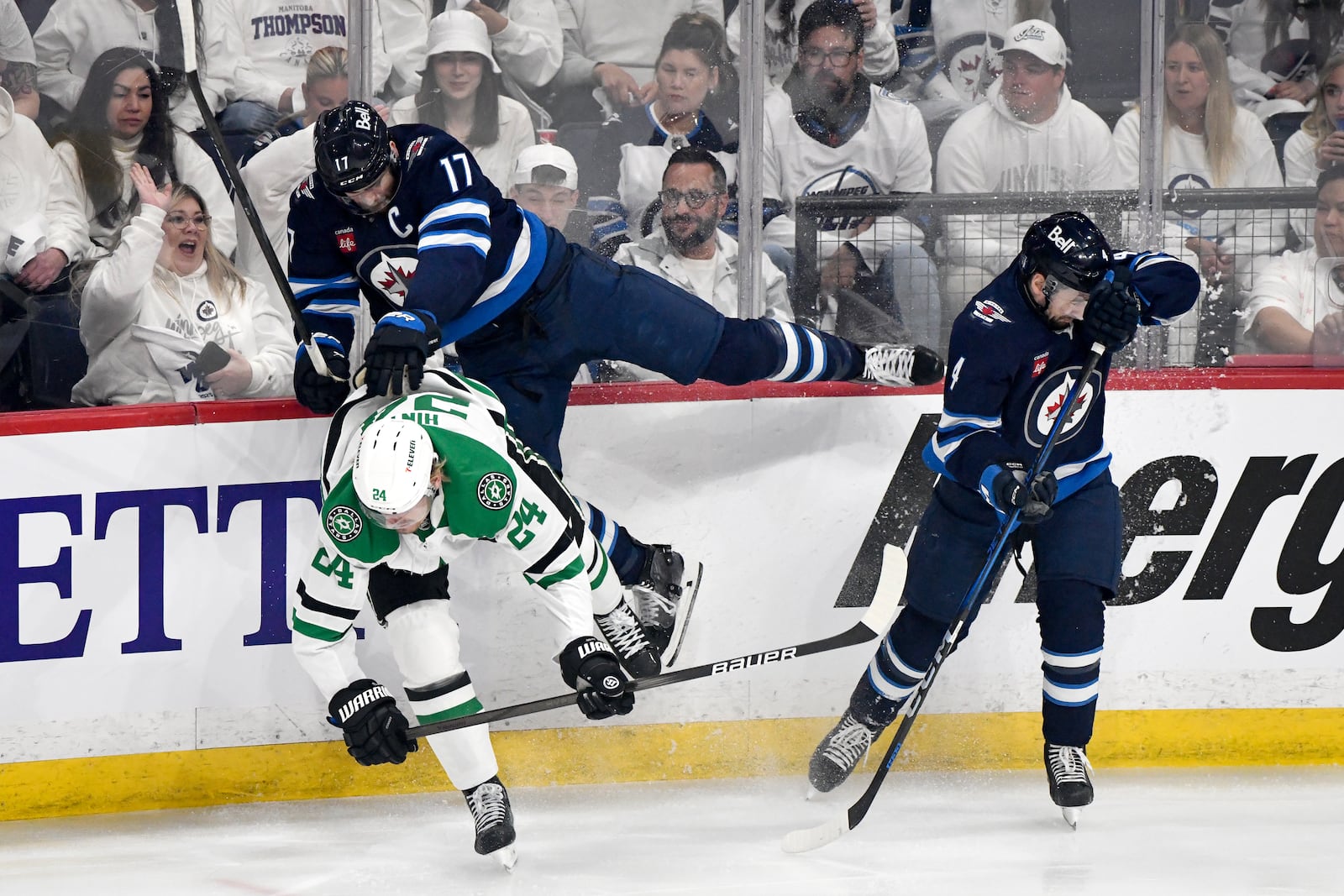 Winnipeg Jets' Adam Lowry (17) and Neal Pionk (4) collide with Dallas Stars' Roope Hintz (24) during first period NHL playoff hockey action in Winnipeg, Wednesday, May 7, 2025. (Fred Greenslade/The Canadian Press via AP)