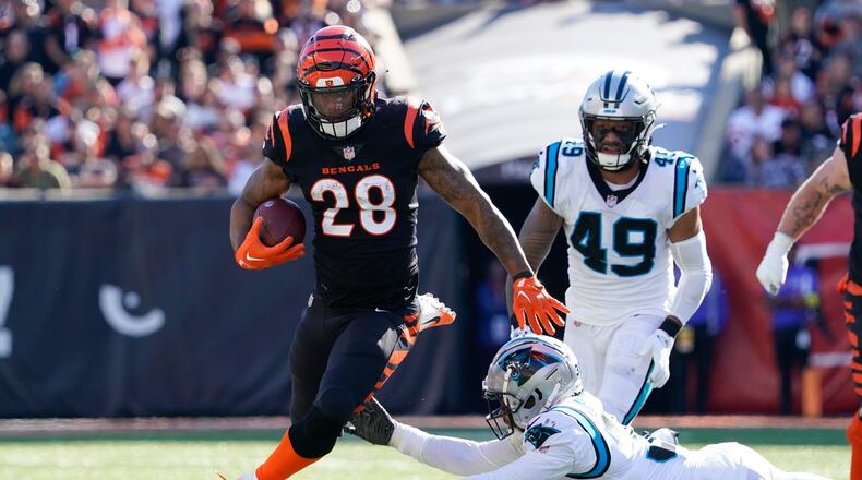 Cincinnati Bengals running back Joe Mixon (28) hops away from Carolina Panthers cornerback Myles Hartsfield (38) on a run during the first half of an NFL football game, Sunday, Nov. 6, 2022, in Cincinnati. (AP Photo/Joshua A. Bickel)