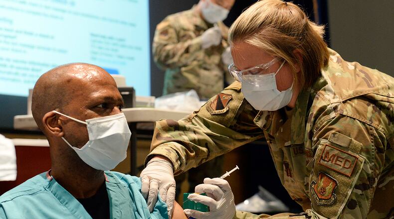Maj. Kito Brooks, an 88th Medical Group podiatrist, receives the COVID-19 vaccine from Capt. Erica Eyer, an 88 MDG flight commander with the Aerospace Operational Medicine Clinic, at Wright-Patterson Air Force Base on Jan. 4. U.S. AIR FORCE PHOTO/TY GREENLEES