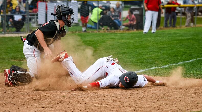 Madison catcher Cameron Svarda tags out Carlisle’s Adam Goodpaster on an attempted steal of home in the first inning Wednesday at Carlisle’s Sam Franks Field. The game was suspended and is scheduled to be finished Thursday. NICK GRAHAM/STAFF