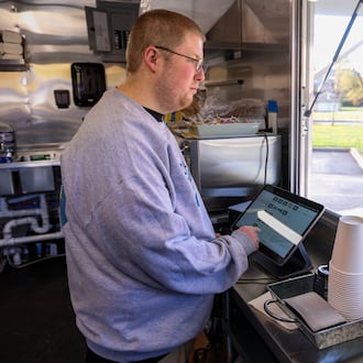 Nathan Prouty rings purchases at the Good Connections food truck on Wednesday, Nov. 12. Prouty is one of the employees of the Goodwill Easterseals Miami Valley program that teaches job skills to individuals with developmental disabilities. BRYANT BILLING/STAFF