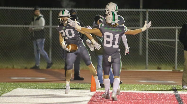 Badin High School senior running back Jack Walsh and teammates junior Braedyn Moore (11) and senior Eric Rawlings (81) celebrate after Walsh scored to give his team the lead late in the fourth quarter in the Division III, Region 12 final against Bellbrook on Friday night at Trotwood Madison High School. The Rams won 21-9 to advance to the D-III state semifinals. Michael Cooper/CONTRIBUTED