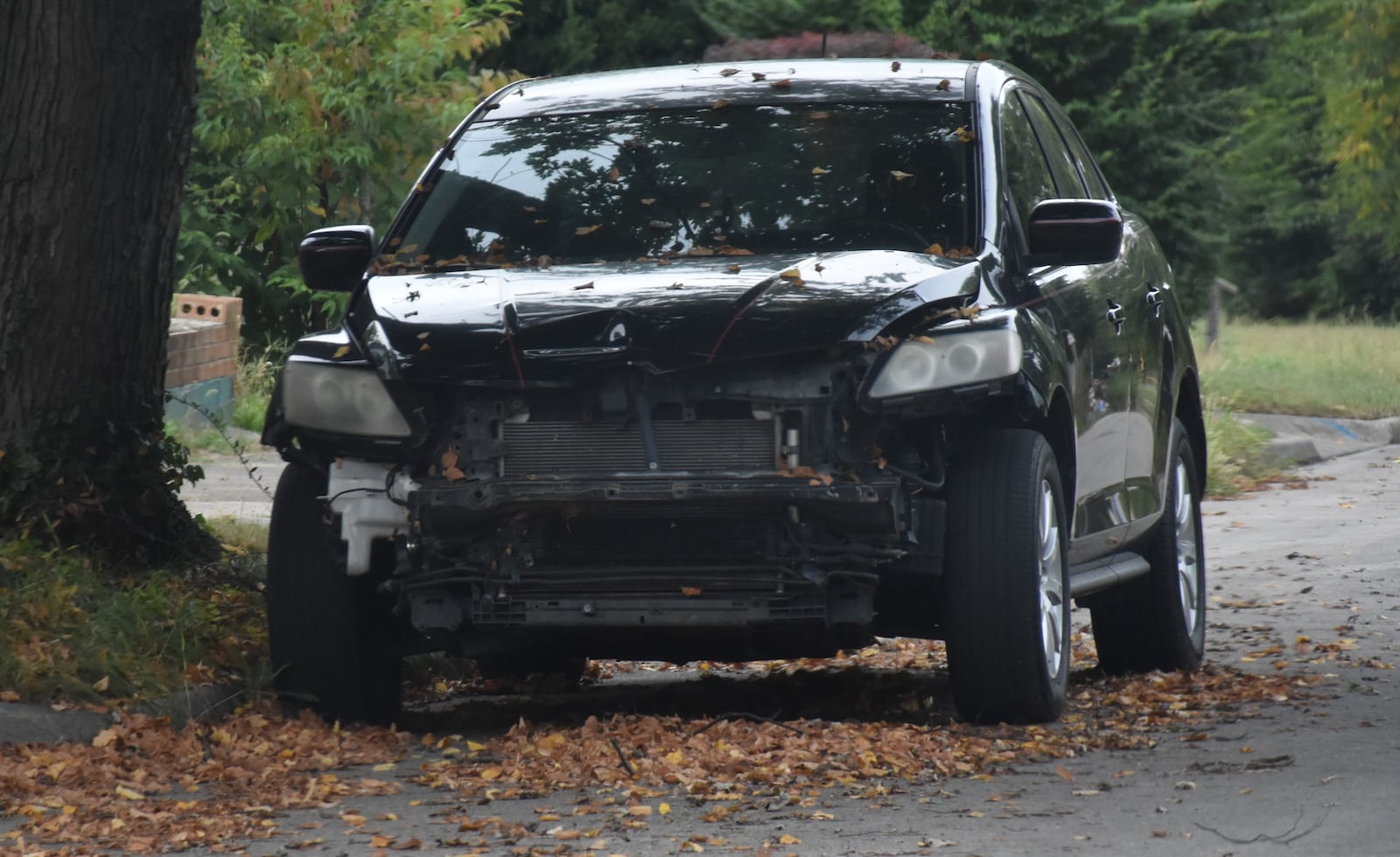 A sedan with front-end damage parked on a residential street in Dayton. CORNELIUS FROLIK / STAFF