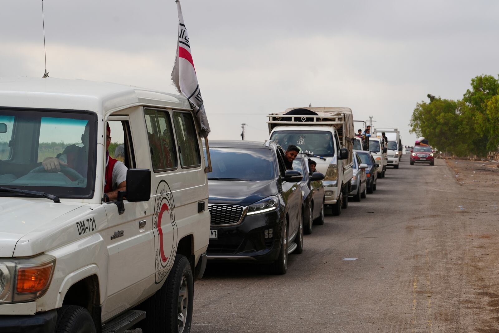 Syrian Bedouin families ride in a convoy led by Red Crescent vehicles in Busra al-Harir, heading to Daraa after being evacuated from Sweida following more than a week of violent clashes, Monday, July 21, 2025. (AP Photo/Malek Khattab)