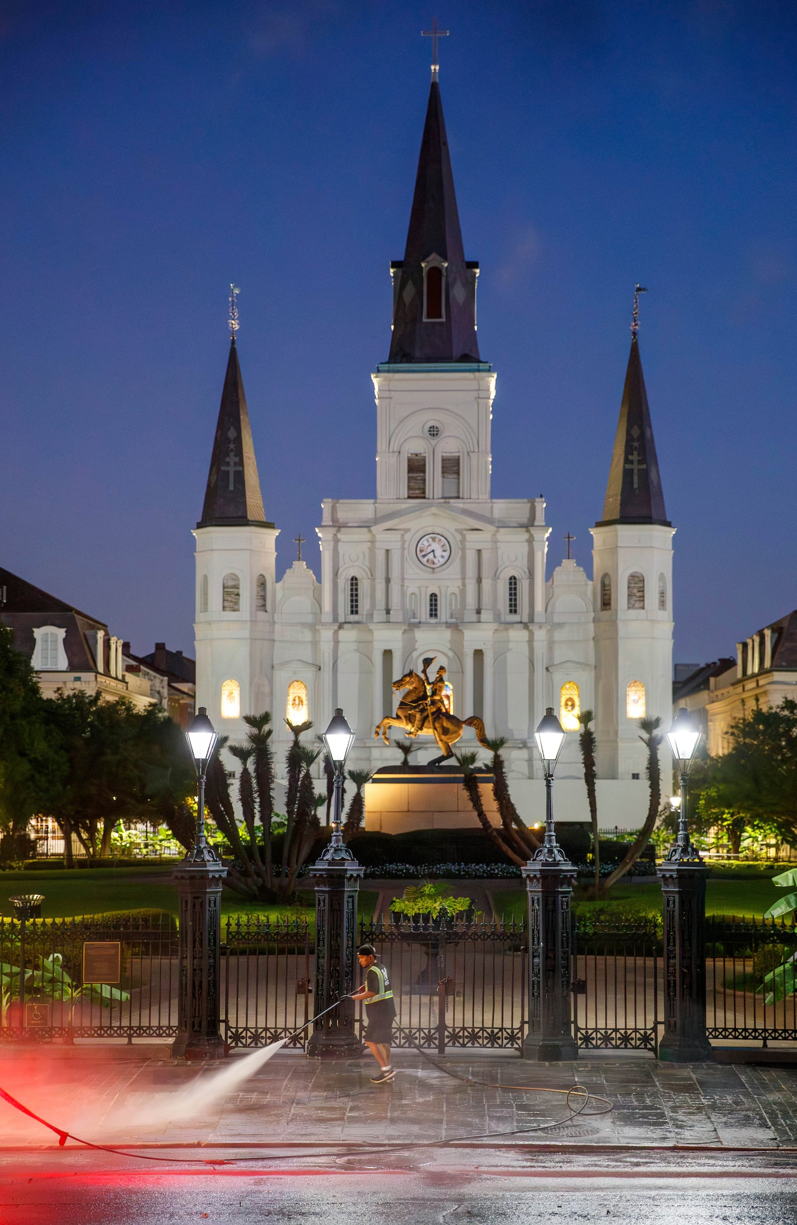 An IV Waste employee pressure washes the sidewalk in front of Jackson Square in the New Orleans French Quarter Monday, July 21, 2025. (David Grunfeld/The Times-Picayune/The New Orleans Advocate via AP)