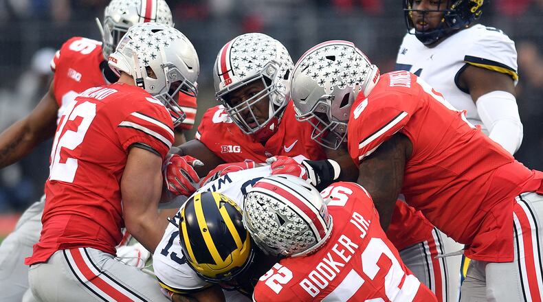 Several Ohio State defenders take down Michigan’s Tru Wilson during the first half of Saturday’s game at Ohio Stadium. Nick Falzerano/CONTRIBUTED