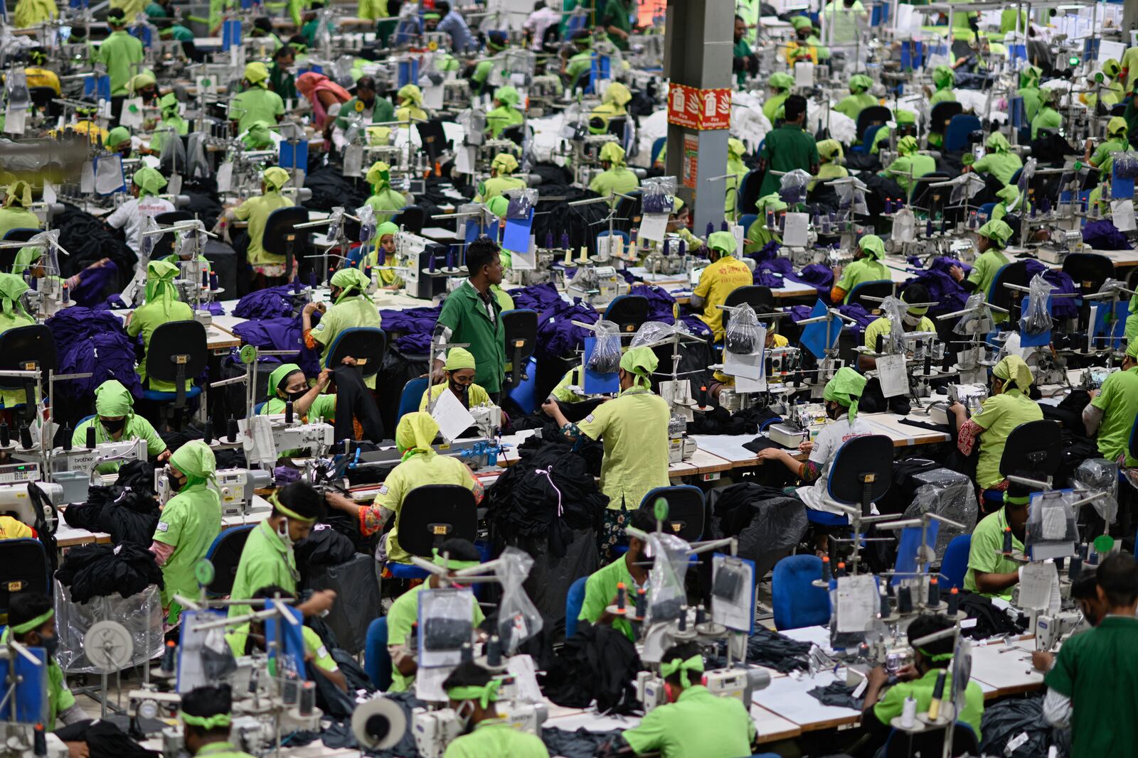 Factory workers operate machines to make garments at UHM Ltd. in Narayaganj, Bangladesh, Tuesday, April 8, 2025. (AP Photo/Mahmud Hossain Opu)