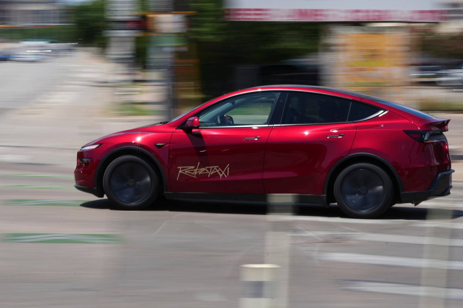 A driverless Tesla robotaxi, a ride-booking service, moves through traffic, Sunday, June 22, 2025, in Austin, Texas. (AP Photo/Eric Gay)