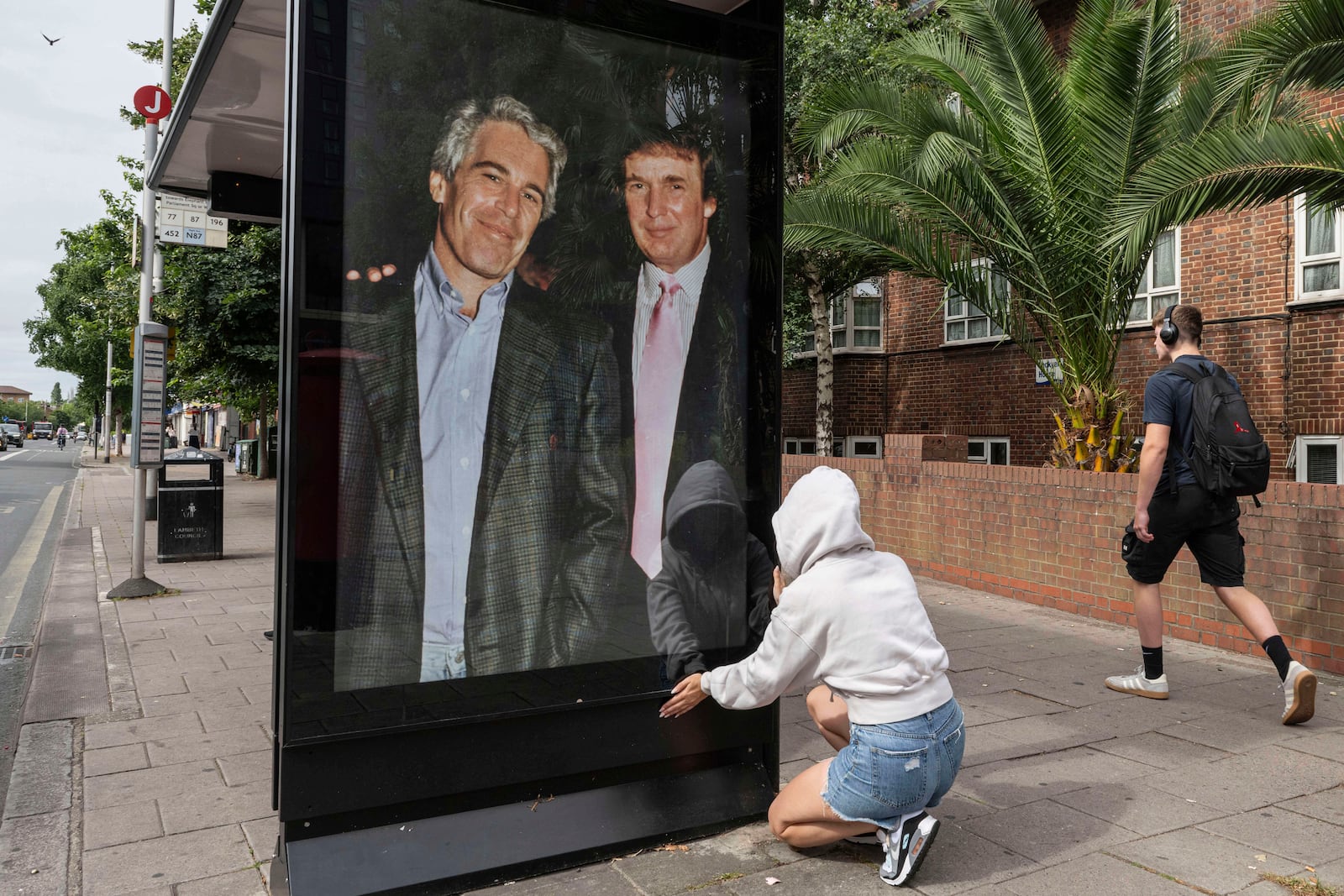 Activists put up a poster showing President Donald Trump and Jeffrey Epstein near the U.S. Embassy in London, Thursday, July 17, 2025.(AP Photo/Thomas Krych)